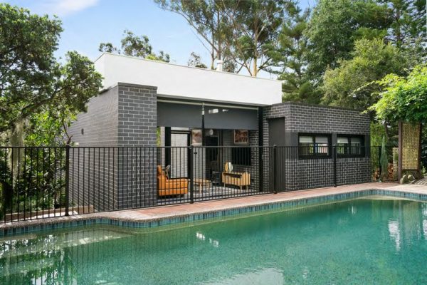 granny-flat-blue-gum-granny-flat-architectural-design-open-plan-living-black-kitchen-bricks-next-to-pool